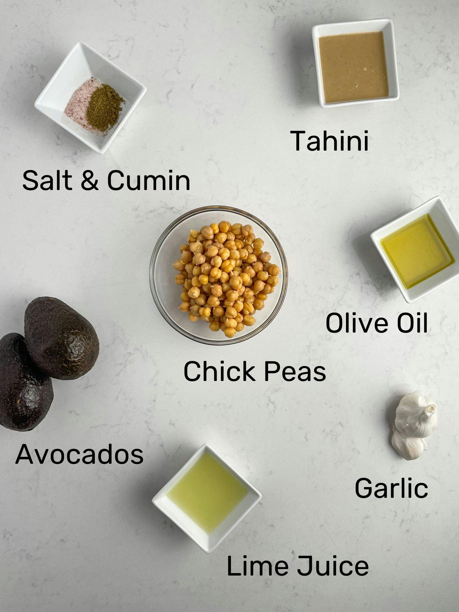 The ingredients of the avocado hummus laid out on a white table.